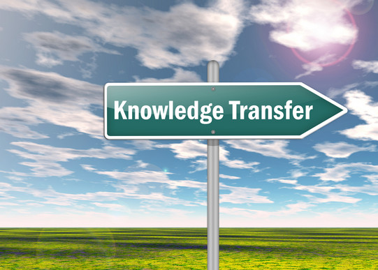 Das Bild zeigt ein Schild in Form eines Pfeils mit der Aufschrift "Knowledge Transfer".