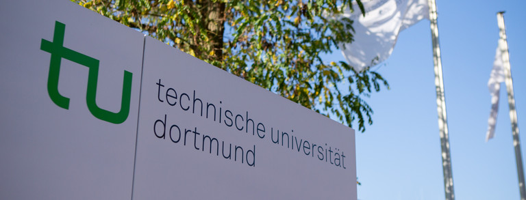 Infotafel am Campus mit der Aufschrift TU Dortmund. 